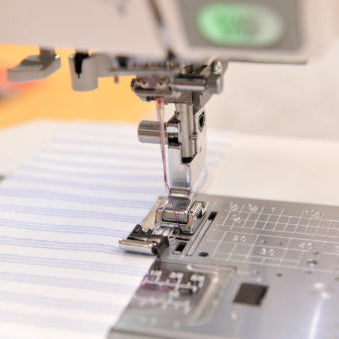 Overkastfot syr på stripete stoff